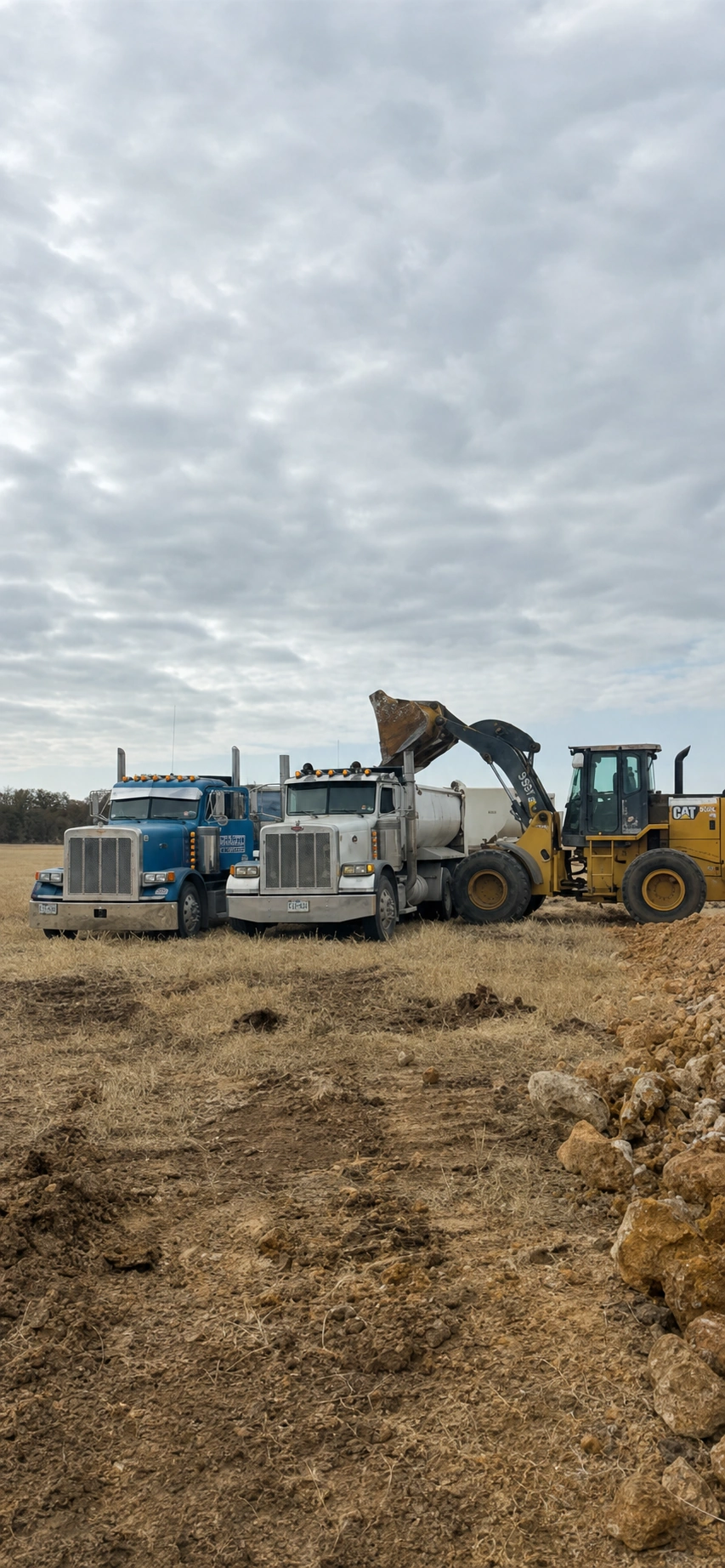 Heavy loader managing aggregate stockpiles at quarry sourcing yard near Dublin, Texas